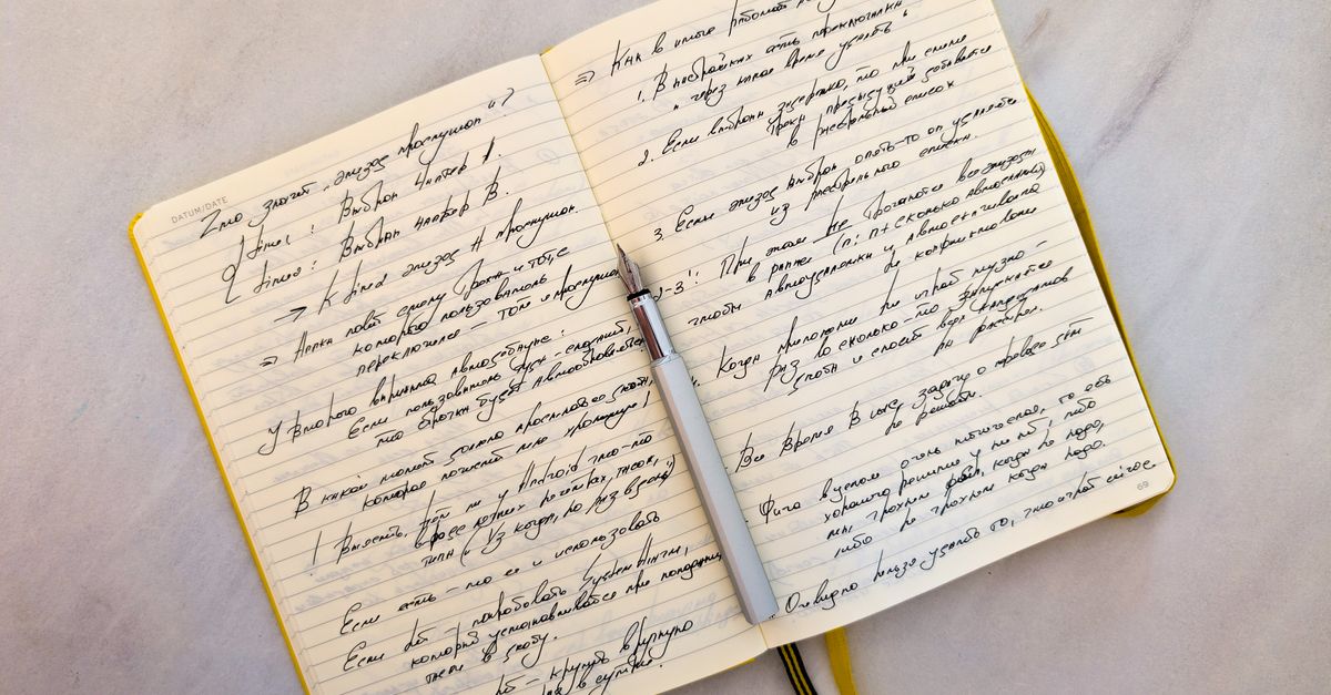 Open notebook with handwritten notes and a pen on a desk